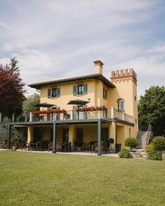 a large yellow house with a balcony with tables at Il Roncal Wine Resort - for Wine Lovers only in Cividale del Friuli