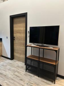 a television on a stand in front of a door at Sun House z balią in Boszkowo-Letnisko
