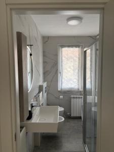 a bathroom with a sink and a toilet and a window at Oasi Lake Iseo in Solto Collina +4 photos