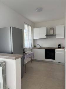 a kitchen with white cabinets and a table in it at Oasi Lake Iseo in Solto Collina