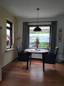 a dining room with a table and chairs and a window at B&B De Zeeaster in Kimswerd