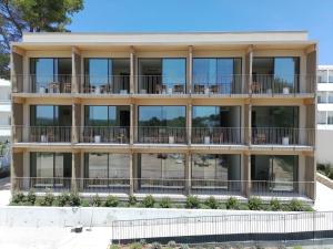 an apartment building with tables and chairs on the balconies at Apartamentos Can Pitet in Es Pujols