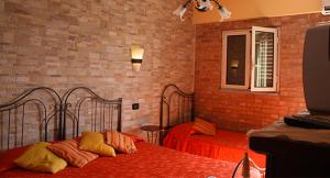 a bedroom with two beds and a brick wall at B&B Angolo Di Paradiso in Pellaro