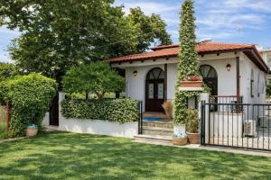 a house with a gate in front of a yard at Villa Shada's pool & Jacouzi in Nea Irakleia