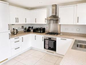 a white kitchen with white cabinets and a sink at Diamond View Stylish 3BR Ideal 4 Professionals in Chilton