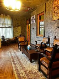 a living room with a table and chairs and a stone wall at Belema Resort & Spa in Jemo