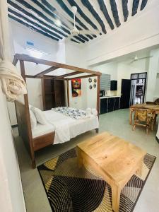 a bedroom with a canopy bed and a table at NorArt House in Zanzibar City +38 photos