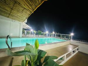 a large swimming pool at night with lights at NorArt House in Zanzibar City
