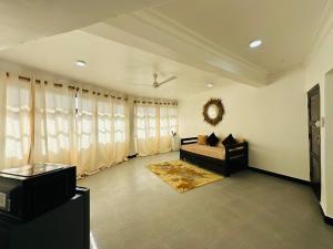 a living room with a couch and a television at NorArt House in Zanzibar City