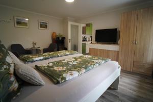 a hotel room with two beds and a flat screen tv at Ferienwohnung Füssel in Rathmannsdorf