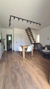 a living room with a table and chairs and a staircase at Officium P49 in Rakamaz