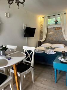 a bedroom with a bed and a table and chairs at Charming apartment piccolo paradiso in Vlašići