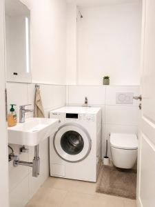 a white bathroom with a washing machine and a sink at Nürnberg Central Flat in Nuremberg