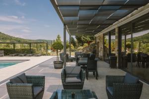 a patio with tables and chairs and a pool at Il Roncal Wine Resort - for Wine Lovers only in Cividale del Friuli +29 photos