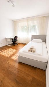 a bedroom with a white bed and a wooden floor at Nürnberg Central Flat in Nuremberg