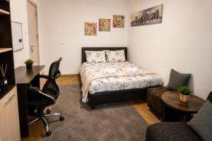a bedroom with a bed and a desk and a chair at Comfortable Room in The City Centre in Varna City