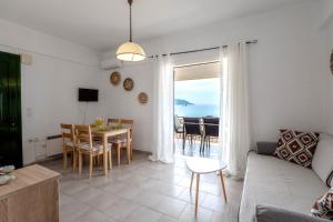 a living room with a couch and a table with a view at Corfu Dream Holidays Villas Standarts in Glyfada