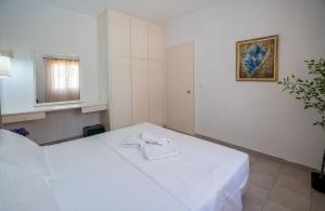 a bedroom with a white bed with a towel on it at Corfu Dream Holidays Villas Standarts in Glyfada