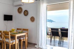 a dining room with a table and a view of the ocean at Corfu Dream Holidays Villas Standarts in Glyfada