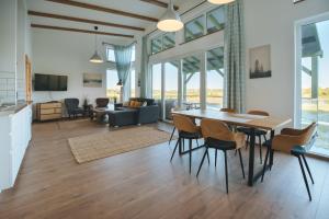 a dining room and living room with a table and chairs at Olivér cölöpház in Tiszafüred