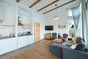 a living room with a couch and a kitchen at Olivér cölöpház in Tiszafüred