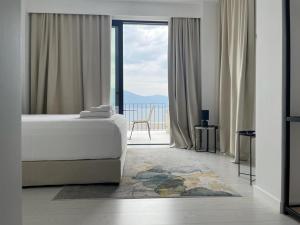 a bedroom with a bed and a view of the ocean at Swiss Rivage Hotel in Vlorë +11 photos