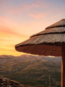 a straw hut on top of a mountain at sunset at Casa do Capucho - Soajo, Gerês in Soajo