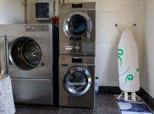 two washing machines and a washer and dryer in a room at Vakantiepark de Meerpaal in Zoutelande