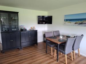 a dining room with a table and chairs at Ferienwohnung Nordseewind in Aventoft