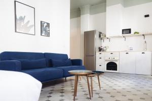 a living room with a blue couch and a table at Casa Alberola Apartments in Alicante