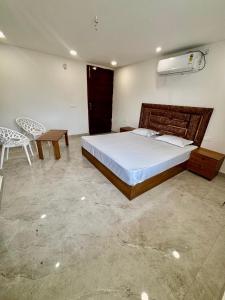 a bedroom with a bed and a table and a chair at Hotel Channo Residency in Nadāmpur +6 photos