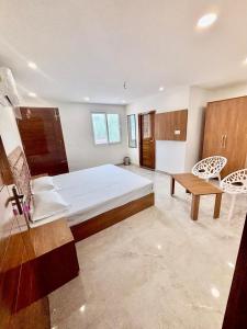 a large bedroom with a large bed and a table at Hotel Channo Residency in Nadāmpur
