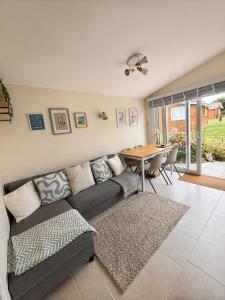 a living room with a couch and a table at The Coastal Cosy, St Merryn, Padstow in Saint Merryn
