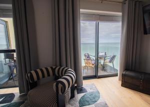 a living room with a balcony with a view of the ocean at Marine View Apartment by Air Premier in Seaford