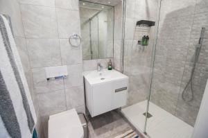 a bathroom with a shower and a toilet and a sink at Marine View Apartment by Air Premier in Seaford +32 photos