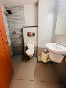 a bathroom with a toilet and a sink at Hotel Holiday Park,Thalassery in Green Island