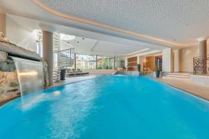 a large swimming pool in a building with a large swimming pool at Apparthotel Talhof, Restaurant, Pool und Spa in Oberau