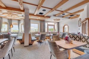 a restaurant with tables and chairs and windows at Apparthotel Talhof, Restaurant, Pool und Spa in Oberau