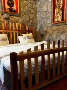 a bedroom with a large bed in a stone wall at Belema Resort & Spa in Jemo