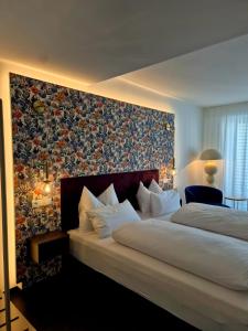 a bedroom with a large bed with a floral wall at Lipmanns Boutique-Hotel in Cochem