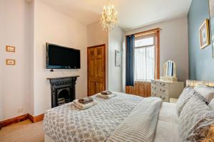 a bedroom with a bed with a fireplace and a tv at 5 Bed in Tynemouth oc-cn125 in Tynemouth