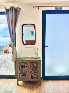a room with a mirror and a table and a door at A Casa Valentina - Estudio vista panorâmica para o mar in Estreito da Calheta