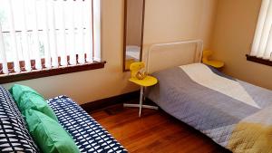 um quarto com 2 camas individuais e uma mesa amarela em Deco Family House em Melbourne