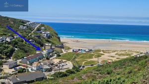 an aerial view of a beach and the ocean at Driftwood in Porthtowan