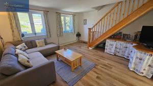 a living room with a couch and a table at Driftwood in Porthtowan