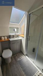 a bathroom with a shower and a toilet and a sink at Driftwood in Porthtowan +38 photos