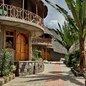 a house with a balcony on top of it at Belema Resort & Spa in Jemo