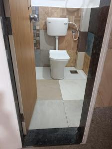 a bathroom with a toilet in a room at White House KMCT in Kapūrwāhāl +22 photos