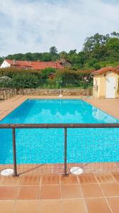 a large blue swimming pool next to a fence at La Casa deMercadillo in Liérganes