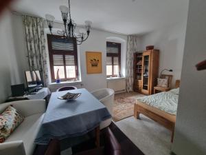 a living room with a table and a bed at Zuhause auf Zeit in Gera